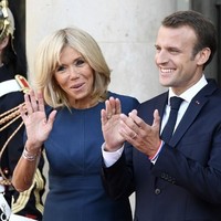 Biru menjadi dresscode pagi itu. Presiden Prancis mengenakan setelan biru hingga dasinya, sementara sang istri bergaun biru pendek. Foto: Dok. LUDOVIC MARIN / AFP