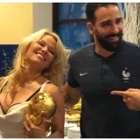 Dalam sebuah foto yang beredar di media sosial, tampak Pamela Anderson ikut memegang trofi Piala Dunia dengan Adil Rami berada di sampingnya. Rumor pertunangan pun merebak karena foto itu. Foto: Instagram/@teamfrenchwags