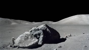 Astronot Harrison H.Schmitt yang berada di misi yang sama dijepret berada di samping bebatuan besar. Terlihat di sisi kanan adalah kendaraan Lunar Roving Vehicle sebagai sarana transportasi dari Lunar Module. Foto: NASA