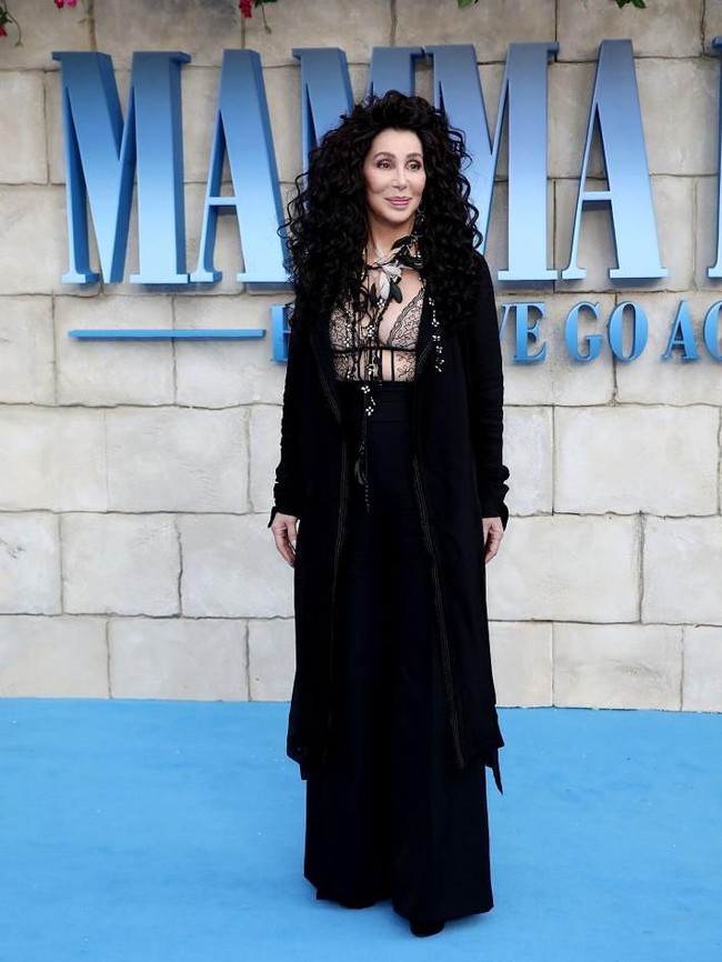 Pada kesempatan itu, Cher mengandalkan busana serba hitam dengan bralet transparan yang mempertegas keseskiannya. Namun coat hitam menjaga penampilannya agar tak terasa berlebihan. (Foto: Getty Images)