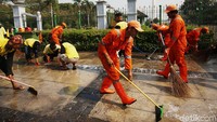 Kotoran yang menempel di atas trotoar dikeruk.
