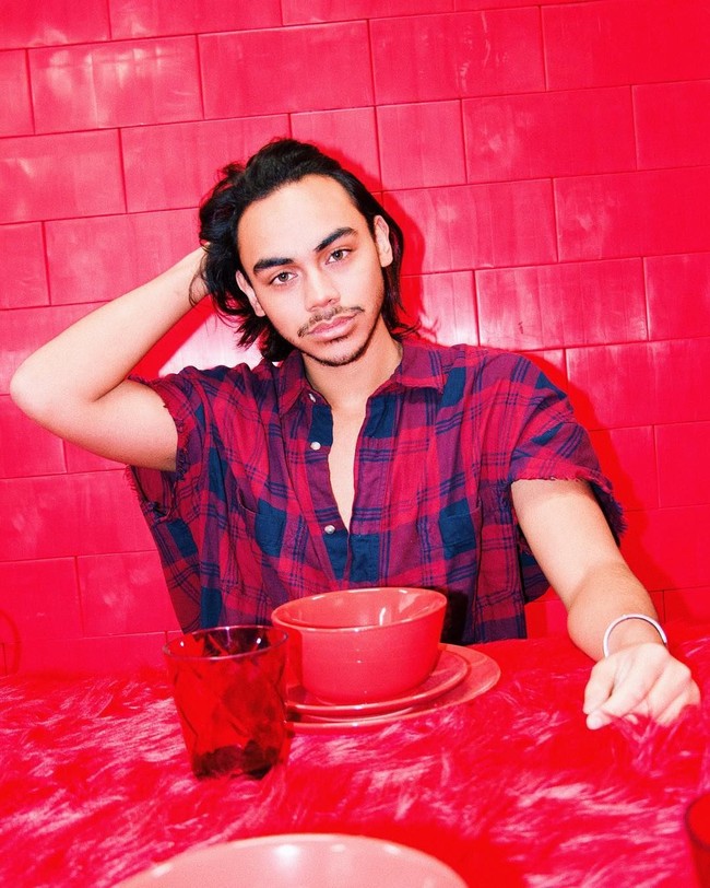 Rafi mencoba menunjukkan sisi macho-nya dengan kemeja merah longgar bermotif kotak-kotak dengan keliman unfinished pada bagian lengan. Kancing kemeja bagian atas dibiarkan terbuka sehingga memberi kesan rileks. (Foto: Instagram/@rafihaikal123)