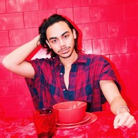 Rafi mencoba menunjukkan sisi macho-nya dengan kemeja merah longgar bermotif kotak-kotak dengan keliman unfinished pada bagian lengan. Kancing kemeja bagian atas dibiarkan terbuka sehingga memberi kesan rileks. (Foto: Instagram/@rafihaikal123)