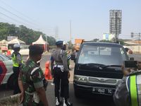 Petugas menegur pengendara yang melanggar uji coba ganjil genap di DI Panjaitan Jakarta Timur