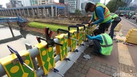 Sejumlah pekerja sedang memasang gigi balang gaya Bewahi di Jembatan Dukuh Atas, Jalan Sudirman, Jakarta Selatan, Kamis (19/7).