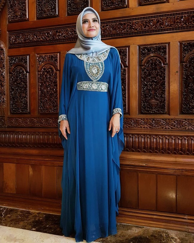 Hijab segi empat berbahan satin juga jadi andalan Tina Talisa untuk acara spesial. Saat merayakan Idul Fitri beberapa waktu lalu, ia tampil cantik dengan kaftan biru dan hijab satin berwarna senada. Foto: Instagram Tina Talisa