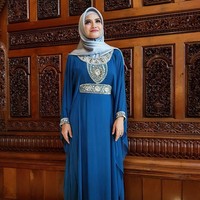 Hijab segi empat berbahan satin juga jadi andalan Tina Talisa untuk acara spesial. Saat merayakan Idul Fitri beberapa waktu lalu, ia tampil cantik dengan kaftan biru dan hijab satin berwarna senada. Foto: Instagram Tina Talisa