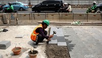 Pembangunan trotoar itu dilakukan dari pagi hingga sore hari. 