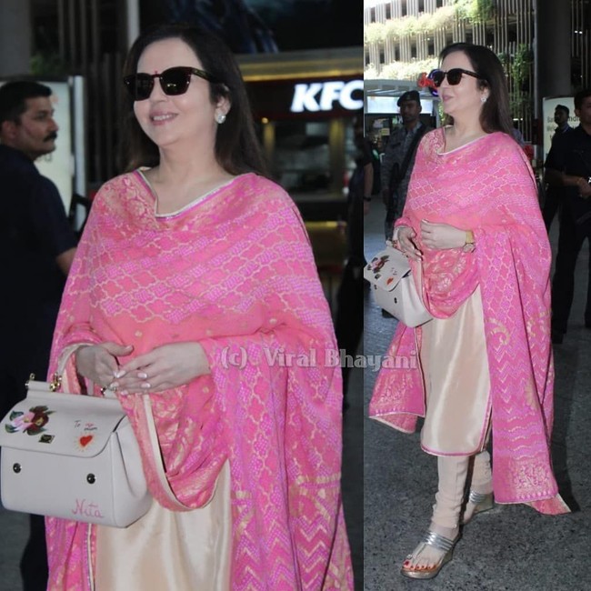 Inilah salah satu airport style Nita Ambani. Saat terlihat di bandara, wanita 54 tahun ini memakai karya desainer terkenal India, Abu Jani Sandeep Khosla. Dia melengkapi gaya mewahnya dengan tas customized dari Dolce & Gabbana bertuliskan To my mum Nita. Tas Dolce & Gabbana yang dipakainya merupakan seri Sicily. Dolce & Gabbana memberikan kesempatan eksklusif pada pelanggan setianya pada September 2017 untuk mendapatkan hiasan nama mereka di Sicily Bag tersebut. Hanya seniman Dolce & Gabbana yang bisa mengerjakan tulisan nama itu. Foto: Viral Bhayani