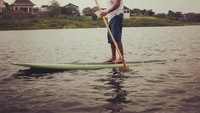 Olahraga paddle board seperti ustadz Hanan dapat memperkuat otot tangan dan melatih keseimbangan. Foto: Instagram/hanan_attaki