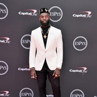 Tampil dandy dengan setelan berjas putih, pemain NFL Malcolm Jenkins memaksimalkan gayanya dengan aksesori bernuansa etnik khas Afrika. (Foto: Alberto E. Rodriguez/Getty Images)