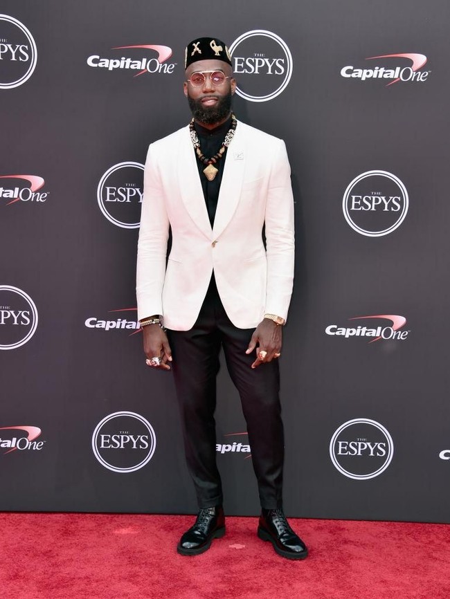 Tampil dandy dengan setelan berjas putih, pemain NFL Malcolm Jenkins memaksimalkan gayanya dengan aksesori bernuansa etnik khas Afrika. (Foto: Alberto E. Rodriguez/Getty Images)