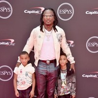 Memboyong kedua anaknya ke karpet merah, atlet football Chris Johnson tampil modis dengan jaket varsity bermotif klasik, celana mengilap, dan sneakers. (Foto: Alberto E. Rodriguez/Getty Images)