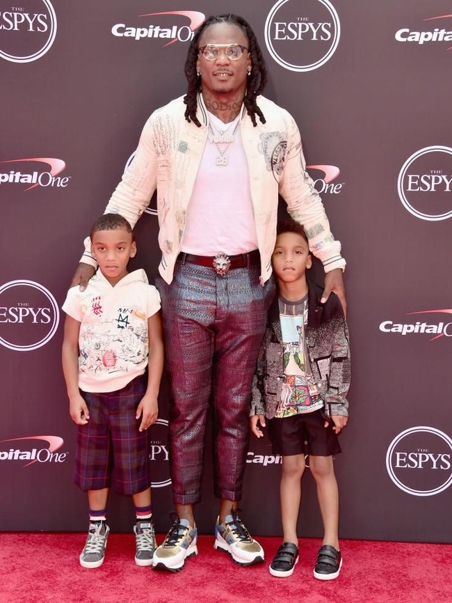 Memboyong kedua anaknya ke karpet merah, atlet football Chris Johnson tampil modis dengan jaket varsity bermotif klasik, celana mengilap, dan sneakers. (Foto: Alberto E. Rodriguez/Getty Images)