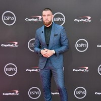 Bintang NFL Travis Kelce tampak gagah dalam balutan setelan kebiruan yang berpadu apik dengan kemeja hitam dan sepatu senada. (Foto: Alberto E. Rodriguez/Getty Images)