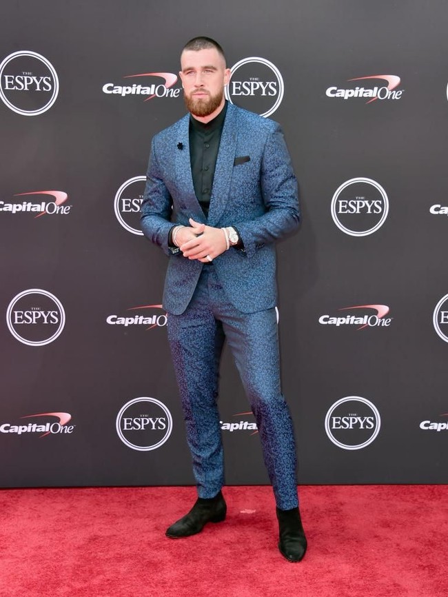Bintang NFL Travis Kelce tampak gagah dalam balutan setelan kebiruan yang berpadu apik dengan kemeja hitam dan sepatu senada. (Foto: Alberto E. Rodriguez/Getty Images)