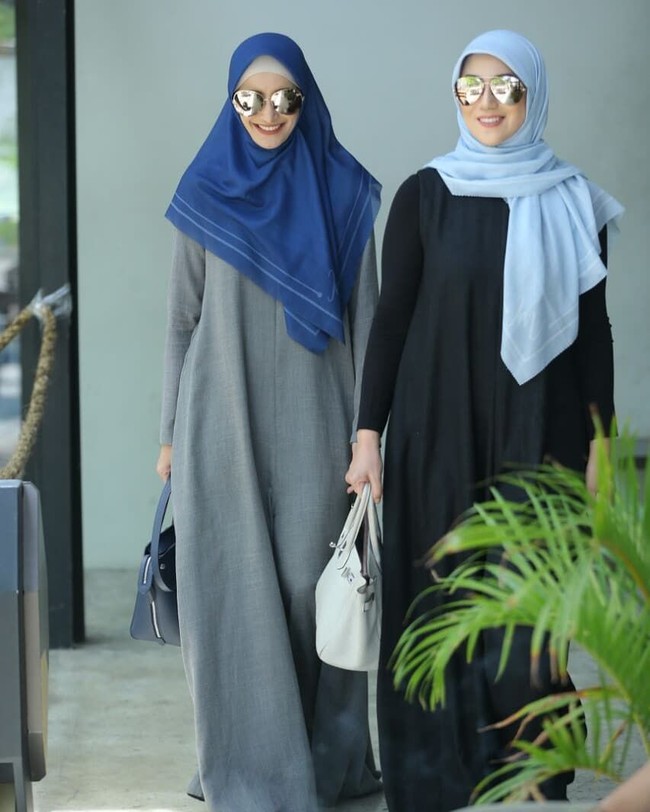 Kaftan bernuansa gelap dipadu kacamata hitam bergaya aviator jadi andalan kedua sahabat ini. (Foto: Instagram/@inekekoesherawati)