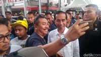 Banyak orang menyiagakan kamera ponselnya di dekat Jokowi sambil tersenyum  