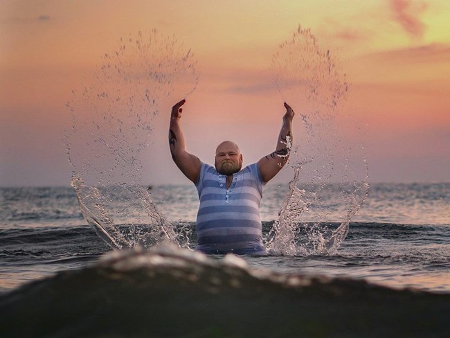 Timofey yang memiliki tubuh gemuk, mengenakan pakaian renang dan melakukan serangkaian foto dengan pose manja di pantai. Foto: Facebook Vodolazky