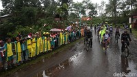 Anak-anak memberi semangat kepada para pesepeda yang membawa obor.