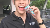 Pemain film SOTUS ini tampak sedang asyik menikmati es krim cone dengan paduan rasa cokelat dengan warna pelangi yang cantik. Foto: Instagram @__singto
