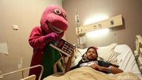 Badut Barney memberikan mainan kepada pasien.