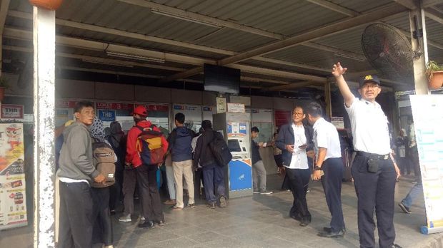 Petugas memberikan informasi dan mengarahkan penumpang yang masih kebingungan akibat pembaharuan sistem ini.