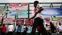 Spanduk tuntutan mereka tempel di pagar gedung DPR.