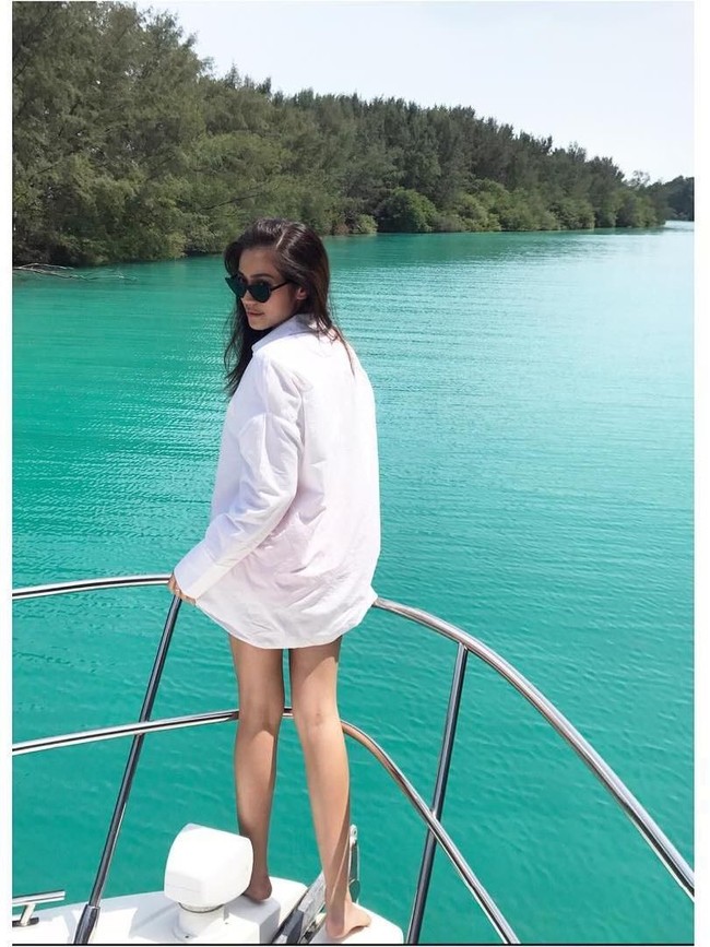 Berpose di atas yacht dengan pemandangan laut biru, Jessica Iskandar tampil seksi berkemeja putih tanpa celana. Tak lupa kacamata hitam sebagai pelengkap busana. Foto: Instagram