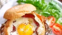 Iris membujur sepertiga tinggi bun burger. Tekan bagian tengahnya hingga cekung. Lapisi sepembar smoked beef, pecahkan telur di dalamnya lalu panggang hingga telur beku. Instagram @heytheresiaFoto: