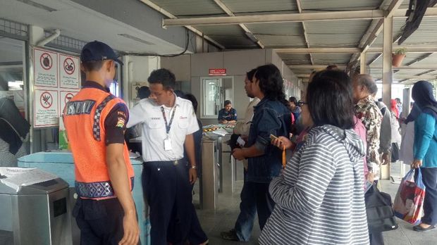 Penumpang menyiapkan uang pas Rp 3.000 untuk membeli tiket kertas.