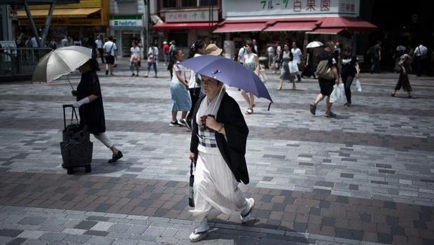 Banyak orang-orang Jepang yang memakai payung agar menghindari panas