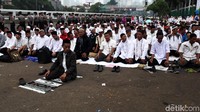 Seorang pendemo memimpin salat berjamaah.