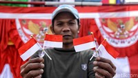 Seorang pedagang memperlihatkan barang dagangnya berupa pernak-pernik bendera di Pasar Warakas, Jakarta Utara, Selasa (24/7).