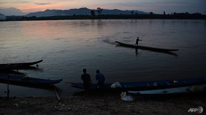 This picture taken on May 29, 2013 shows a fisherman standing on his boat as he lays his net in the Mekong river in Wiang Kaen, a district in the northern Thai province of Chiang Rai, bordering Laos. (Photo: AFP/Christophe Archambault) Read more at https://www.channelnewsasia.com/news/asia/hundreds-missing-in-laos-after-dam-collapse-report-10558270