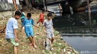 Membawa serta penyaring ikan yang dibuat seadanya dari kerangka kipas angin, anak-anak ini mencari ikan kecil di sekitar sungai yang kotor tersebut.