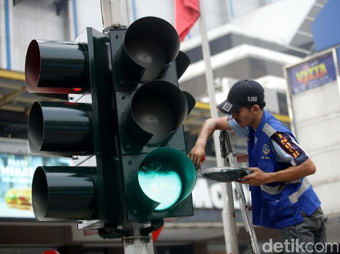 Sejumlah petugas Dinas Perhubungan tengah melakukan perbaikan dan perawatan lampu lalu lintas di kawasan Sarinah, Jakarta.
