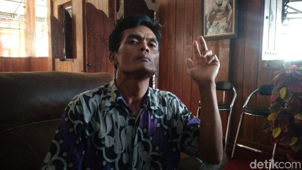 Dadang memperagakan pose yang sama dengan pria di bungkus rokok