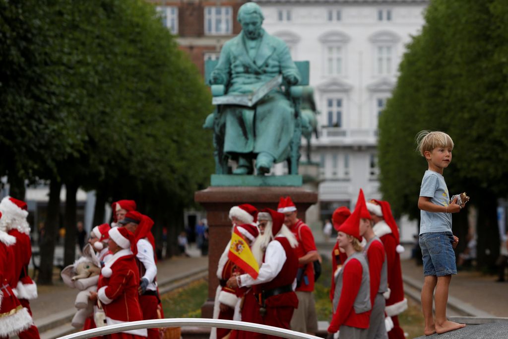A child reacts as a parade of people dressed as Santa Claus passes during the World Santa Claus Congress, an annual event held every summer in Copenhagen, Denmark, July 23, 2018.  REUTERS/Andrew Kelly