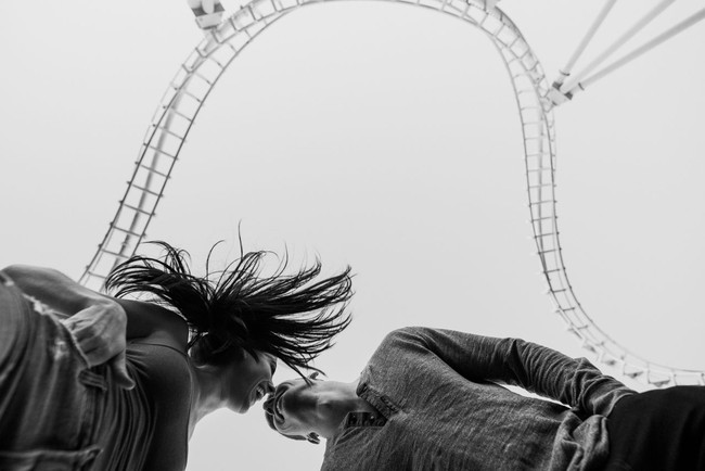 Dalam nuansa warna hitam dan putih, foto ini tetap terlihat menyenangkan berlatar roller coaster. Foto: Dok. Junebug Weddings/Ken Pak of Ken Pak Photography