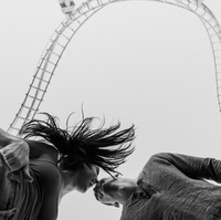 Dalam nuansa warna hitam dan putih, foto ini tetap terlihat menyenangkan berlatar roller coaster. Foto: Dok. Junebug Weddings/Ken Pak of Ken Pak Photography