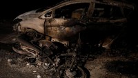 Sejumlah korban yang ditemukan tewas dievakuasi di bawah sebuah mobil dan sepeda motor di kota pelabuhan Rafina, yang diketahui sebagai wilayah paling berdampak akibat kebakaran tersebut. Alkis Konstantinidis/Reuters.
