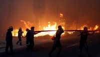 Pihak kepolisian dan pemadam kebakaran masih terus melakukan evakuasi dan mengatasi api agar tak menyambar ke bagian yang lebih luas. Costal Baltas/Reuters.