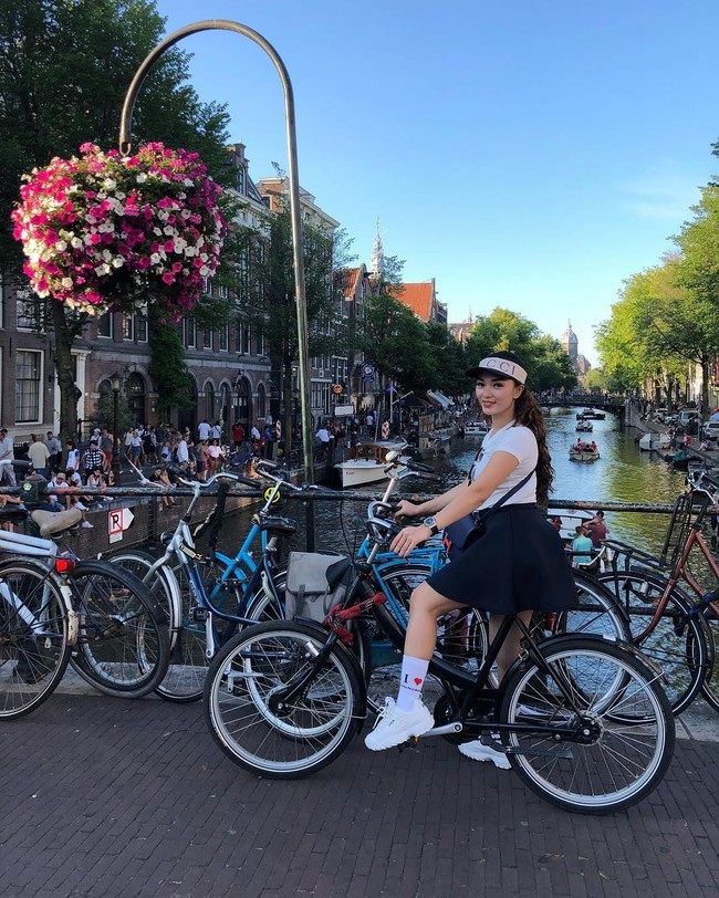 Masih di Belanda, kali ini Zaskia Gotik bergaya di kota sepeda Amsterdam. Rok mini dan kaus putih serta tas Hermes masih menjadi gaya andalannya. Namun kali ini sepatu boots digantinya dengan sneakers Fila. Dia juga melengkapi gaya casualnya dengan kaus kaki dan topi Gucci. Dalam situs resmi Gucci, topi jenis baseball hat with Gucci headband berwarna hitam dan putih itu dibanderol seharga Rp 5 jutaan. Foto: Instagram