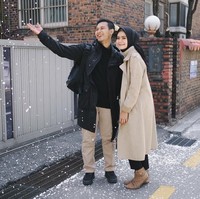 Ingin tampil matching saat traveling? Curi gaya Fairuz Sakinah dengan suaminya. Tak memakai coat yang berwarna senada, tapi keseluruhan tampilan mereka memiliki tone warna yang sama. Foto: Instagram/Fairuzsakinah