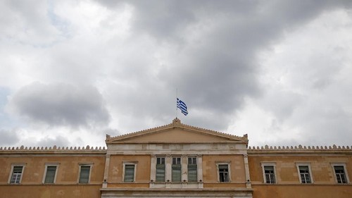 A Greek national flag flies at half mast over the parliament building as a period of national mourning is declared for the victims of wildfires, in Athens, Greece, July 24, 2018. REUTERS/Costas Baltas