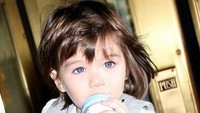 Nah, foto ini diambil saat Suri masih kecil. Mata birunya kelihatan cantik banget ya. Makin mungil karena ia sambil memegang botol susu. Foto: instagram @suricruise.official