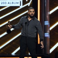 Berjaya di Billboard Music Awards 2017, Drake tampil modis dengan padanan polo shirt hitam, celana formal, dan sepatu oxford berwarna senada. (Foto: Getty Images)