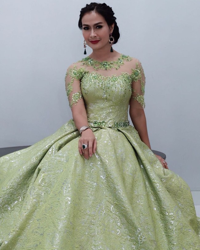 Iis Dahlia bergaya heboh serba hijau untuk acara Kontes Dangdut Indonesia (KDI). Dia memakai anting panjang berdetail fringe yang senada dengan ball gown warna hijaunya. Foto: Instagram @ isdadahlia