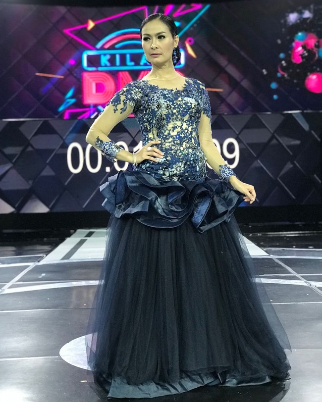 Iis Dahlia terlihat mengenakan gaun yang sungguh meriah sat menjadi juri kontes dangdut. Bagian body gaun dihiasi bordir dan payet. Dan pada area pinggangnya dipenuhi ruffle sehingga membuat Iis terlihat lebih berisi.  Foto: Instagram @ isdadahlia